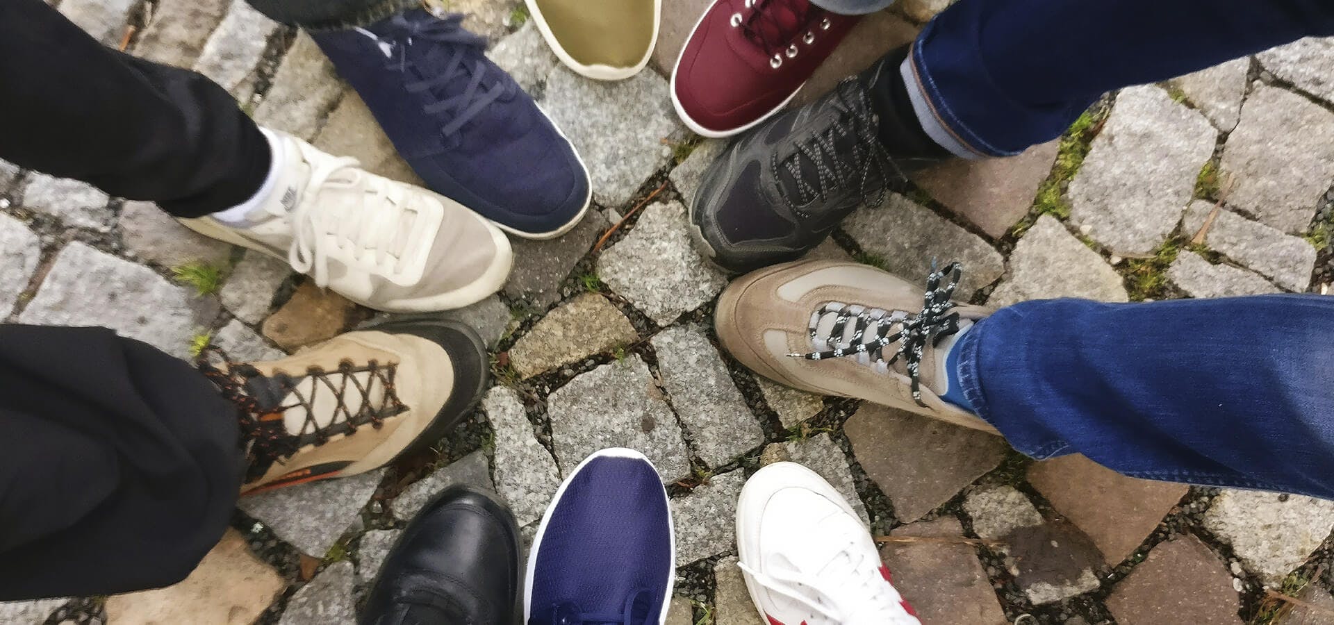 Grupo de amigos juntando su calzado en el suelo
